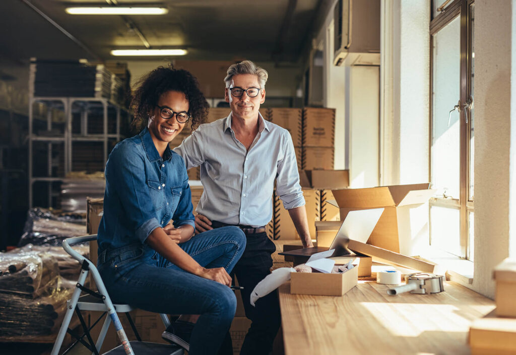 Pair of business owners in their new warehouse space after applying for a commercial property loan