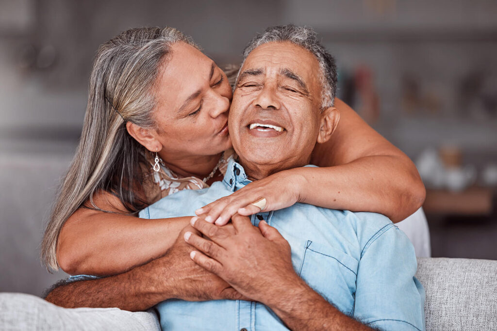 retired couple with ira accounts embracing on couch