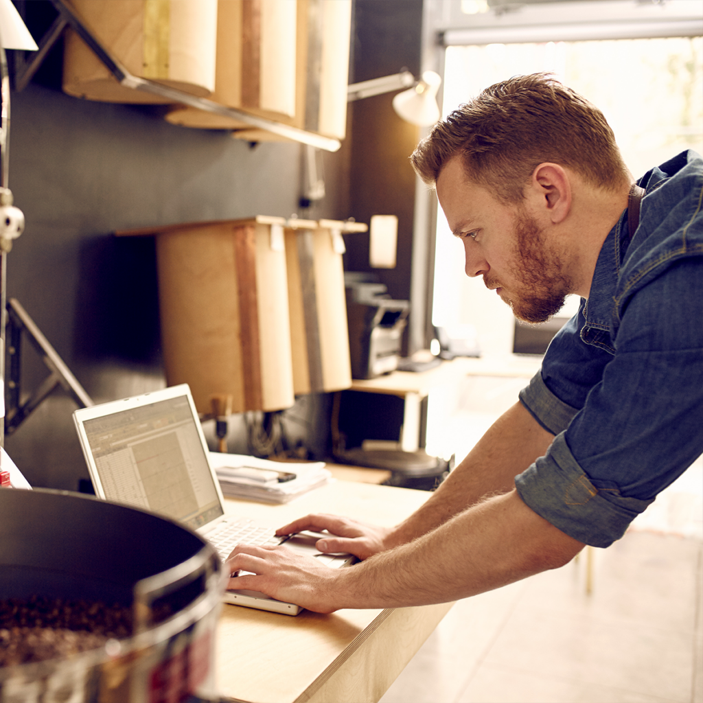 Man on a laptop in office opening up a commercial line of credit online