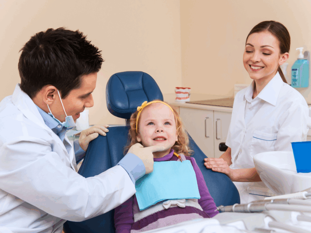 a child in a dental check up with her dentist and hygenist in an office recently financed with a dental practice loan