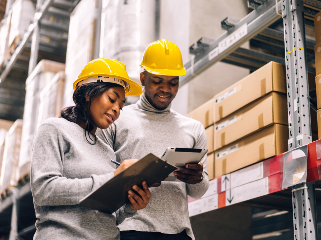 owners of a manufacturing company discussing sba loans for manufacturing companies in their warehouse