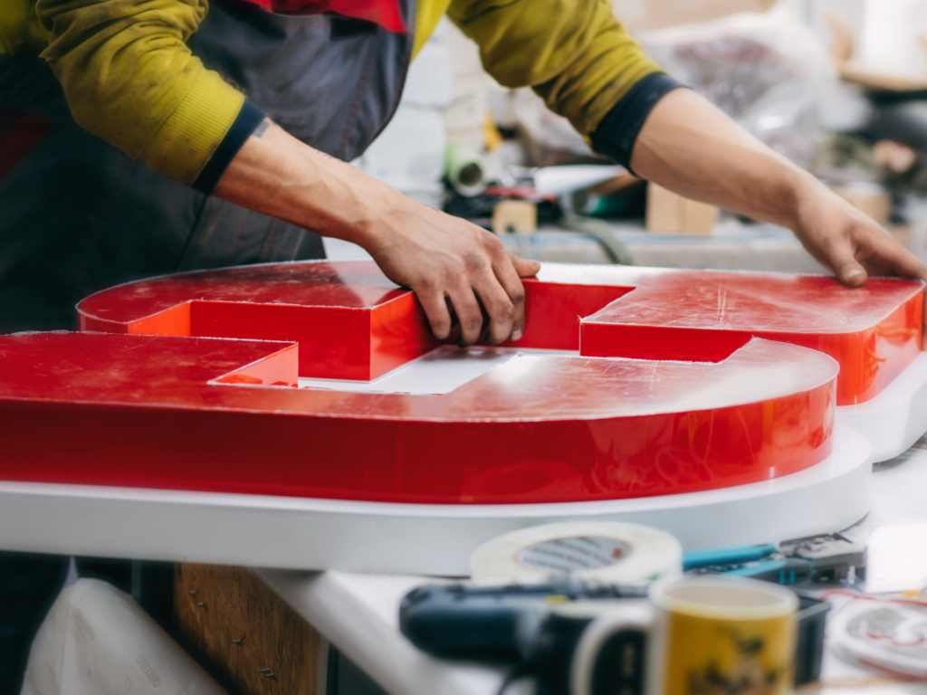 From Service to Small Business Ownership: How SBA Financing Helped a Veteran Acquire a Signarama Franchise 2 a sign maker in a sign franchise working on an order in a business acquired with financing from quaint oak bank with an sba loan