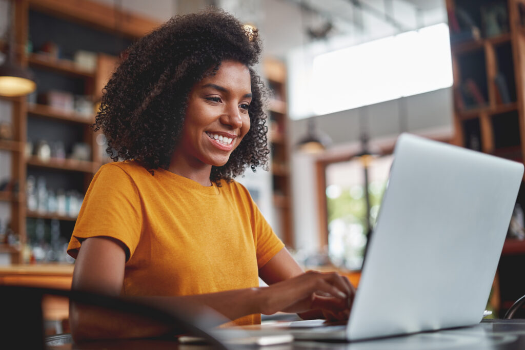 Mujer feliz usando una computadora portátil para investigar Quaint Oak Opciones de Certificado de Depósito