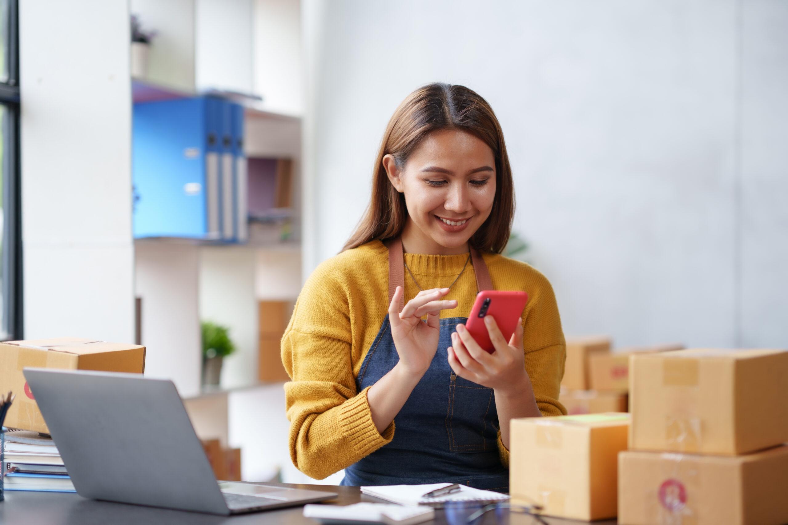 Woman business owner reviewing banking tips and finances on her phone in her shop
